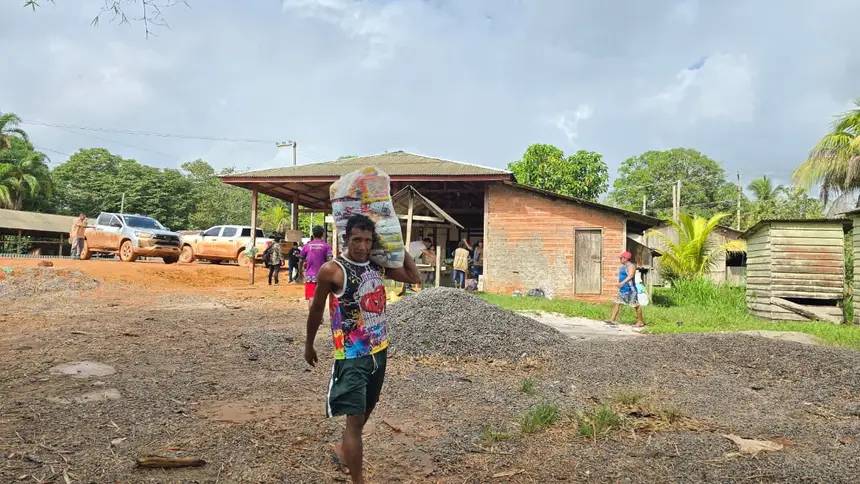 Indígenas ajudam carregar os kits de alimentos às embarcações 