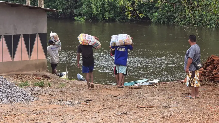 Indígenas ajudam carregar os kits de alimentos às embarcações