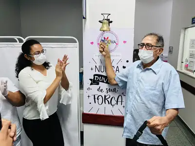 notícia: Com a família e amigos, radialista toca o sino que celebra fim do seu tratamento de quimioterapia na unidade oncológica do Governo do Amapá