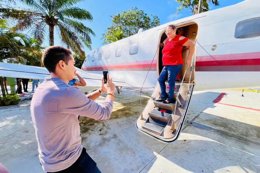 Paciente posa pra foto após conhecer parte interna do avião Bandeirante