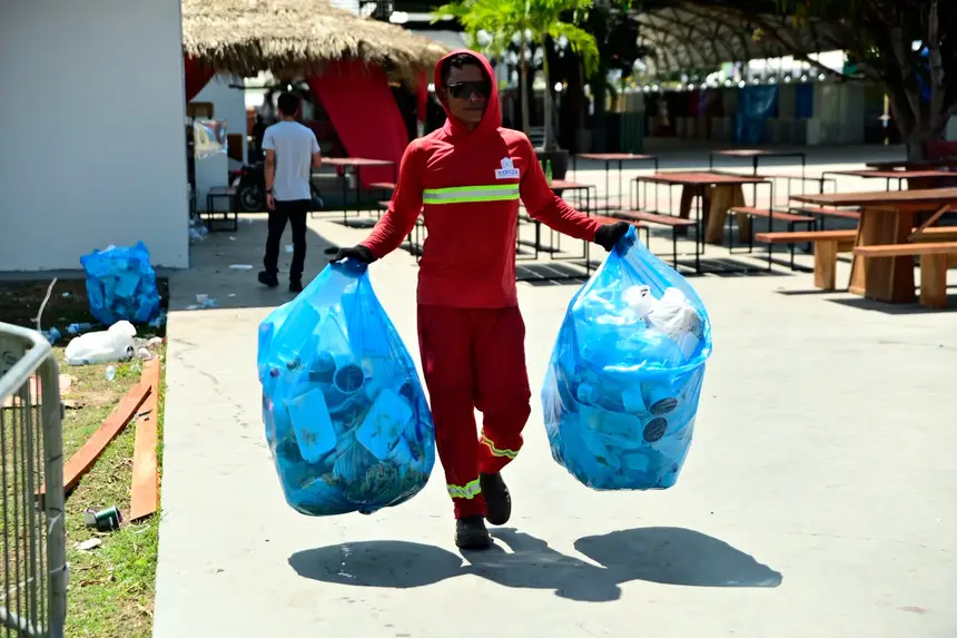 Agente de limpeza carrega sacos de resíduos recolhidos no Parque de Exposições